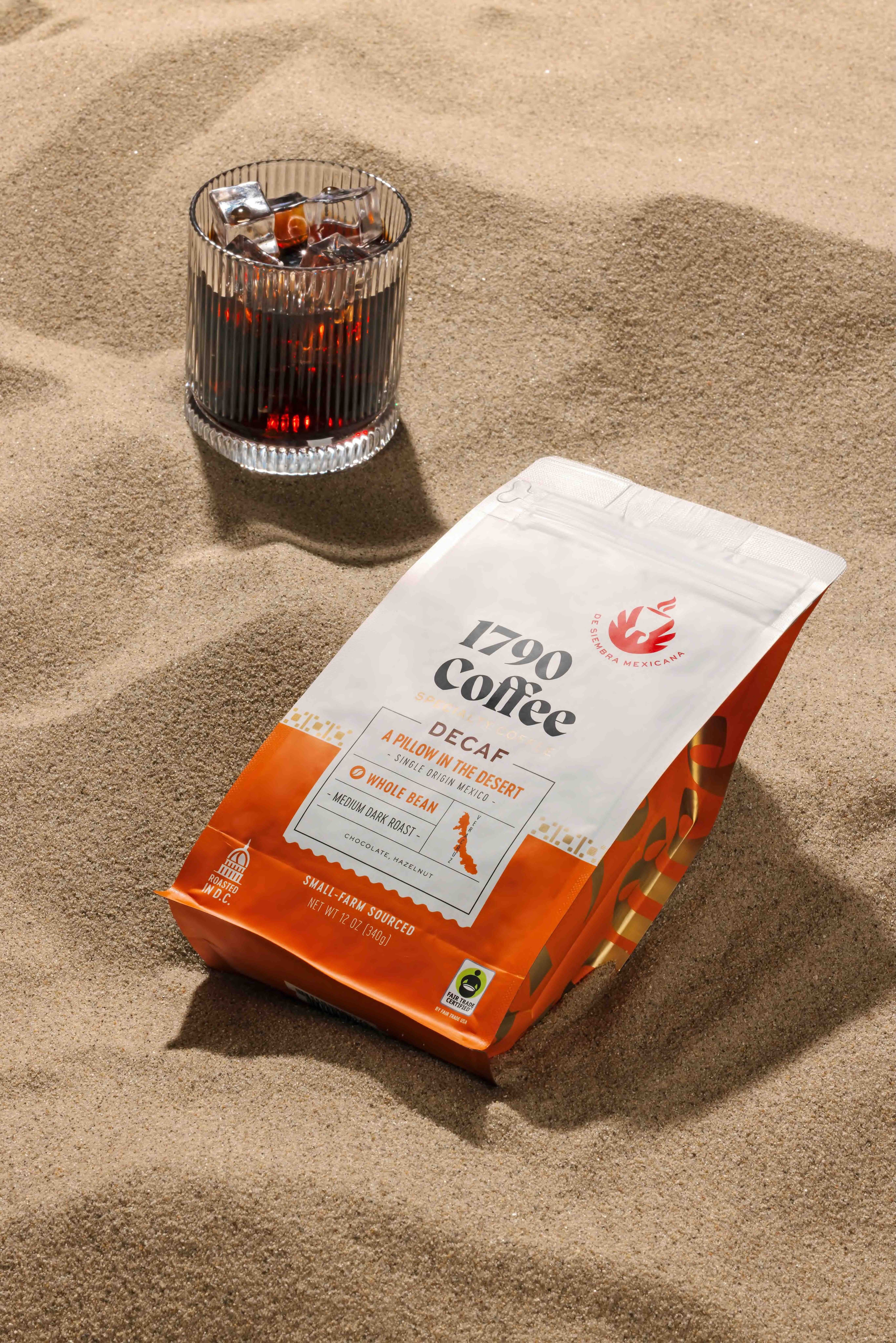Bag of 1790 Coffee A Pillow in the Desert decaf in the sand with a glass of coffee